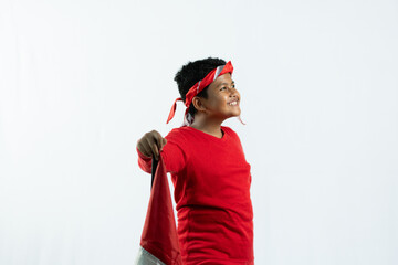 Asian children hold the red and white Indonesian national flag and wear red and white clothing to commemorate Indonesia's independence day. isolated white background