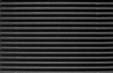 A sheet of black glossy corrugated cardboard texture as background