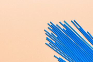 Heap of colorful plastic drinking straws on Colored background, flat lay. Copy Space for text