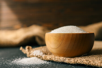 Sugar in a wooden bowl on burlap