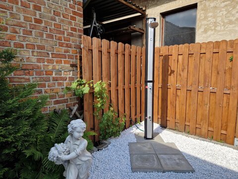 Gartendusche Solar vor Holzzaun f&uuml;r den Sommer