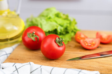 Ripe tomatoes for preparing vegetable salad on a wooden board. Salad cooking process. Close-up.