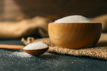 Sugar in a wooden bowl on burlap