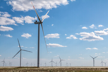 Large wind farm in a field on a clear sunny day