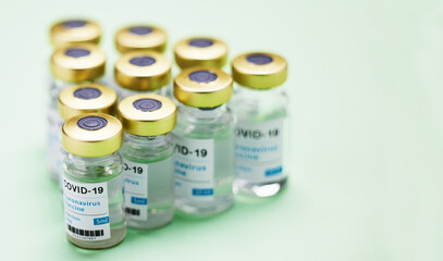 Medical, Covid vaccine and bottle in studio, emergency health care for pandemic. Green background, glass container and medicine with research for virus, chemistry development for human wellness