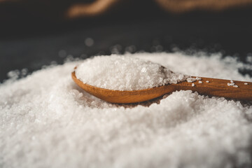 Wooden spoon with salt, splash, top view
