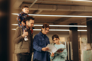 A young family looks through a catalogue in a hardware store