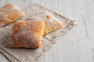 Homemade Cheese Ciabatta Buns on a white wooden background, side view. Copy space.