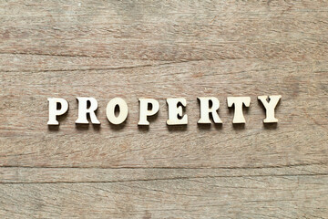 Fototapeta premium Alphabet letter block in word property on wood background