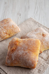 Homemade Cheese Ciabatta Buns on a white wooden background, side view. Copy space.