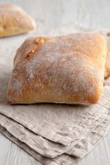Homemade Cheese Ciabatta Buns on a white wooden background, side view. Close-up.
