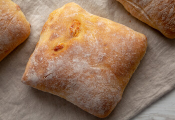 Homemade Cheese Ciabatta Buns on a white wooden background, top view.
