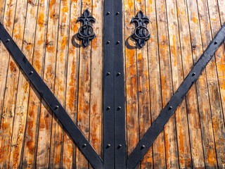 The ancient wooden gates in the fortress are reinforced with metal plates. Gates in ancient times.