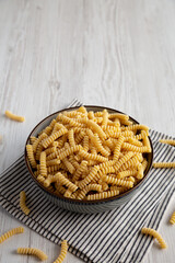 Raw Dry Organic Italian Fusilli Corti Bucati in a Bowl, side view. Copy space.