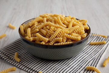 Raw Dry Organic Italian Fusilli Corti Bucati in a Bowl, side view.