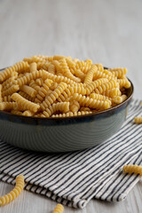 Raw Dry Organic Italian Fusilli Corti Bucati in a Bowl, side view.