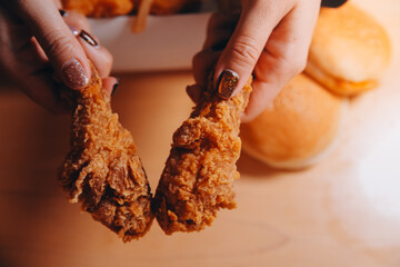 close up focus woman hand hold fried chicken for eat,girl with fast food concept