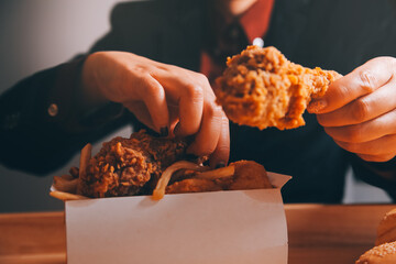 close up focus woman hand hold fried chicken for eat,girl with fast food concept © ARMMY PICCA