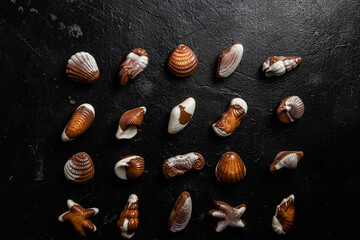 Chocolate candies in the shape of shells on a dark background