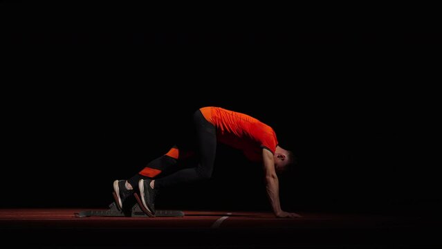Runner Standing On Starting Blocks For Start, Side View Of Sportsman Preparing To Sprint Race