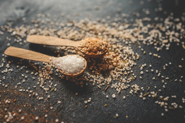 Wooden spoons with different spices on a black background, banner