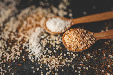 Wooden spoons with different spices on a black background, banner