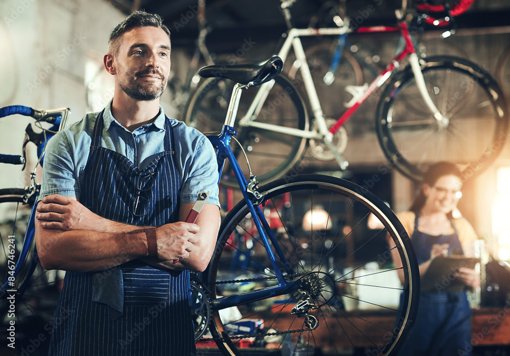 Wall mural Man, bicycle mechanic and professional with confidence in small business for fix, repair or maintenance. Confident male person, cycle technician or bike engineer with tool or equipment at workshop