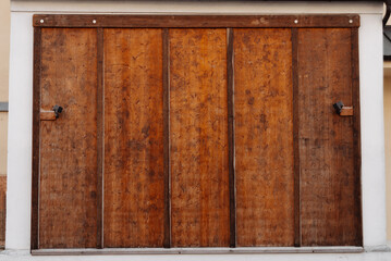 A rustic wooden sliding barn door is shown mounted on a white wall, highlighting its natural...