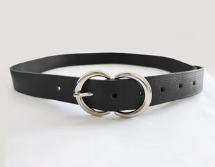 Black leather women's belt with metal buckle on white background