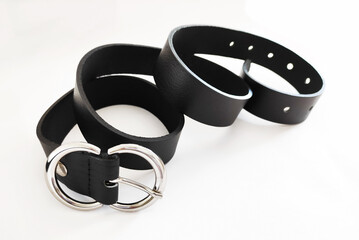 Black leather women's belt with metal buckle on white background