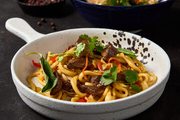 Asian-Style Udon Noodles with Beef and Vegetables - Lagman Dish in White Bowl