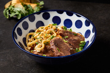 Handcrafted Beef Brisket Udon in an Asian-Style Broth with Fresh Herbs and Noodles