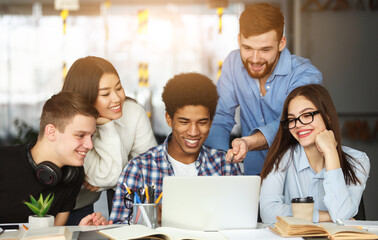 Fototapeta premium Education concept. University students using laptop in library, preparing for lectures