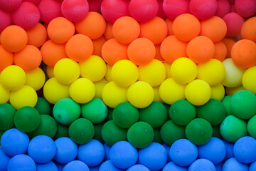 Vibrant and colorful display of rainbow-colored balls arranged in a spectrum, symbolizing the LGBT pride and celebration of diversity. Lively shot of the essence of unity and inclusivity