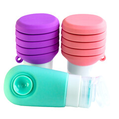 Colorful travel toiletry bag containers, shampoo and shower gel bottles, made of silicone. Reusable, refillable and sustainable. Isolated on transparent background.