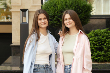 Portrait of two beautiful twin sisters outdoors