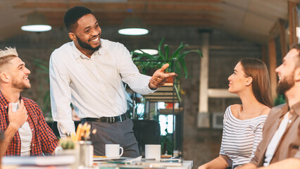 Enthusiastic team members participate in a lively discussion during a friendly office meeting in a modern workspace.