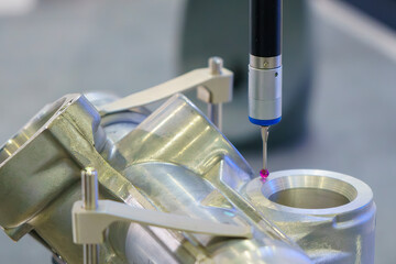 The  CMM probe measuring the  aluminum automotive parts.