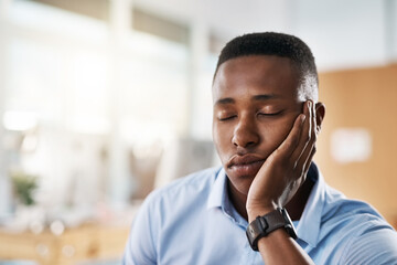Sleeping, relax or tired black man in office overwhelmed by deadlines with fatigue or burnout. Lazy worker, depressed consultant or exhausted professional resting or taking nap on hand in business