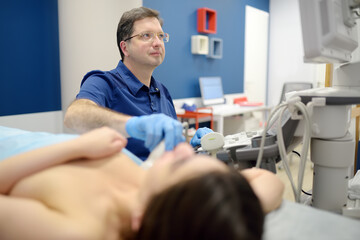 Mammologist doctor examines a woman breasts and lymph nodes using ultrasound. Mammography and...