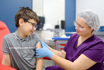 A little boy is being vaccinated. A child is very afraid of the injection. Schoolkid nervous during...