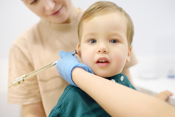 Baby and his mother are being seen by a pediatric neurologist in medical clinic. Doctor conducts...