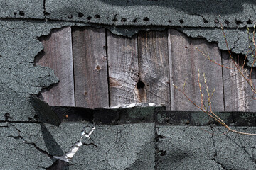 An old barn damaged asphalt shingles wall
