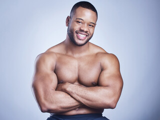 Black man, arms crossed and topless in studio with fitness for healthy body, portrait and muscle with confidence. Bodybuilder, athlete or happy with wellness, arm strength or power on blue background