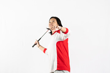 Young Asian woman wearing Indonesian clothing is holding a racket and playing badminton. isolated white background