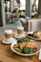 croissant sandwiches and coffee cups on wooden table