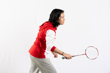 Young Asian woman wearing Indonesian clothing is holding a racket and playing badminton. isolated white background