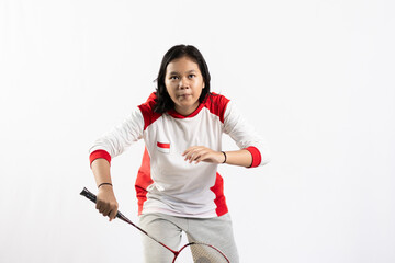Young Asian woman wearing Indonesian clothing is holding a racket and playing badminton. isolated white background