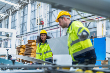 Fototapeta premium male and female technician engineers checking the process on Heavy machine. mechanical engineering team production. Industry manufacturing. Worker holding tablet and folde. High technology production.
