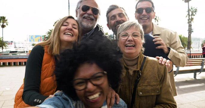 Multi-ethnic group of middle-aged people taking a selfie during a vacation. Happy middle aged friends